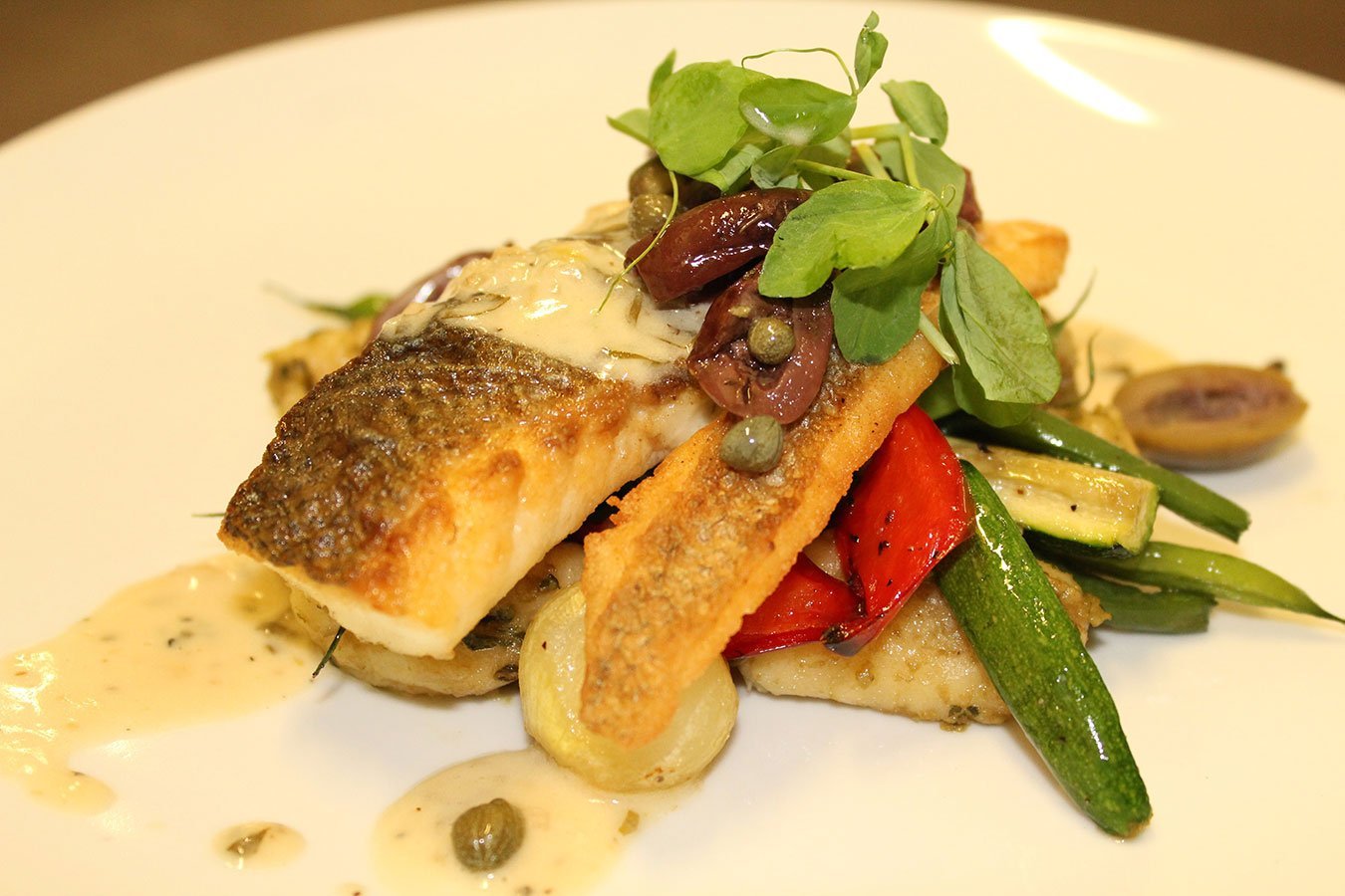 Pan Roasted Branzino with Tomato, Olive, Caper and Tarragon. Served with Pesto Gnocchi and Roasted Baby Vegetables