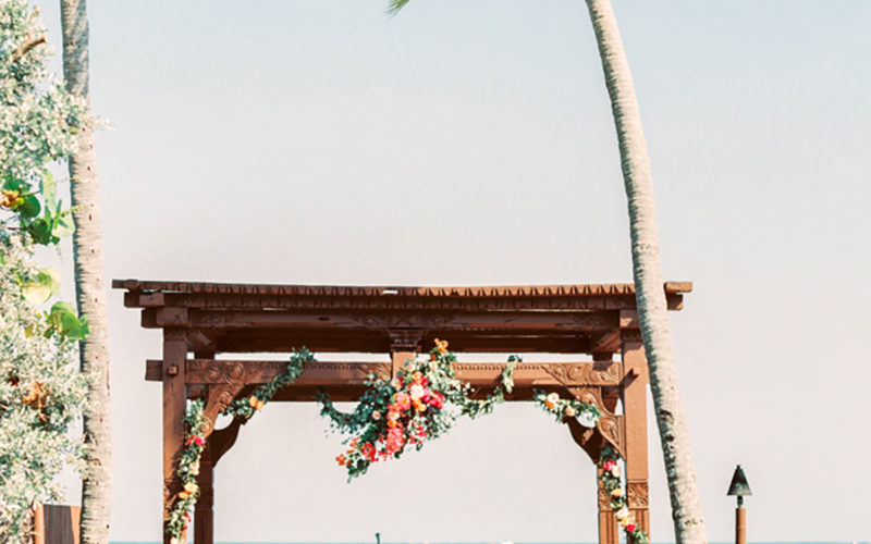 Wedding arbor wrapped with bougainvillea, eucalyptus, orange lisianthus, pink hydrangeas and peach roses were wrapped around the front posts of the ornate wedding arbor at The Caribbean Resort in Islamorada