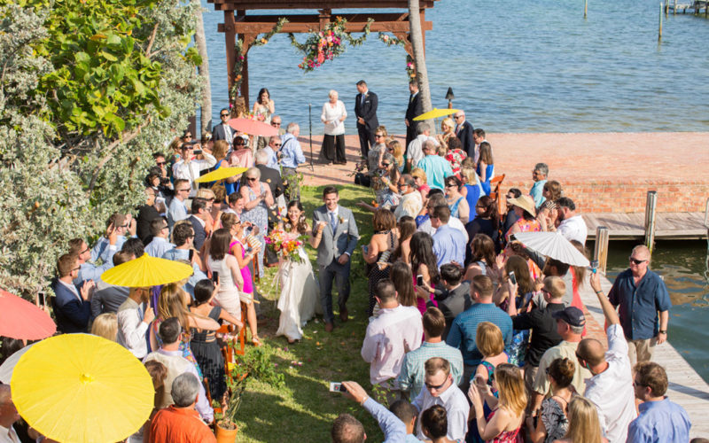 Guests were ready for the Florida heat with bright yellow, coral and white parasols at this waterfront wedding at the Caribbean Resort in Islamorada, FL