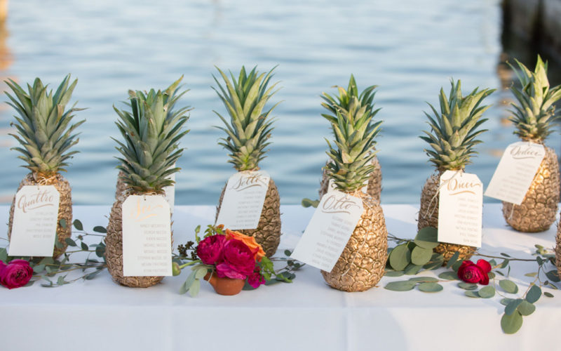 Handwritten seating chart with gold painted pineapples at this waterfront wedding