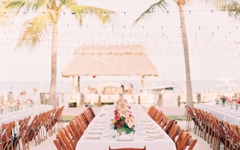 Bright wedding reception centerpieces gave the table settings a pop of color at this waterfront wedding