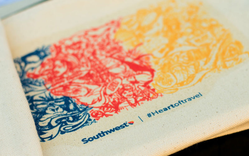 Ruben Ubiera mural printed on custom canvas pouches live on site at the Southwest #Heartoftravel event at FATVillage Arts District