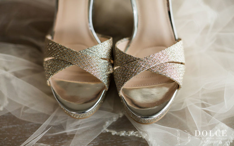 Neutral wedding shoes with a hint of metallic blush gold perfectly complement the purple wedding colors of the bridal bouquet