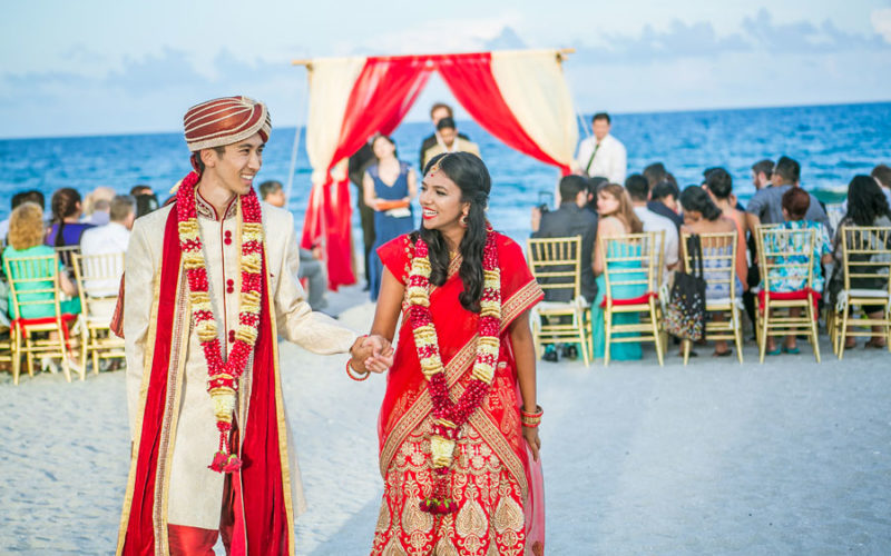 Couple exits their Indian beach wedding ceremony on Delray Beach