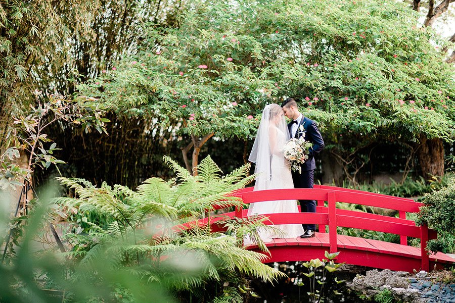 Couple on red bridge in the Japanese garden at their Miami Beach Botanical Garden wedding