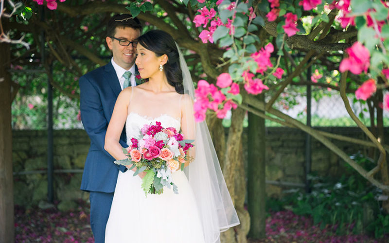 Couple under the bougainvillea at their Fairchild Tropical Botanic Garden wedding