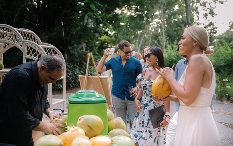 tropical wedding theme | guests enjoy fresh coconut milk